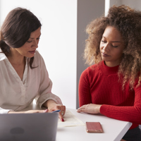 2 Women at a desk discussing something on a paper
